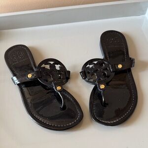 Tory Burch black patten leather flat sandals.